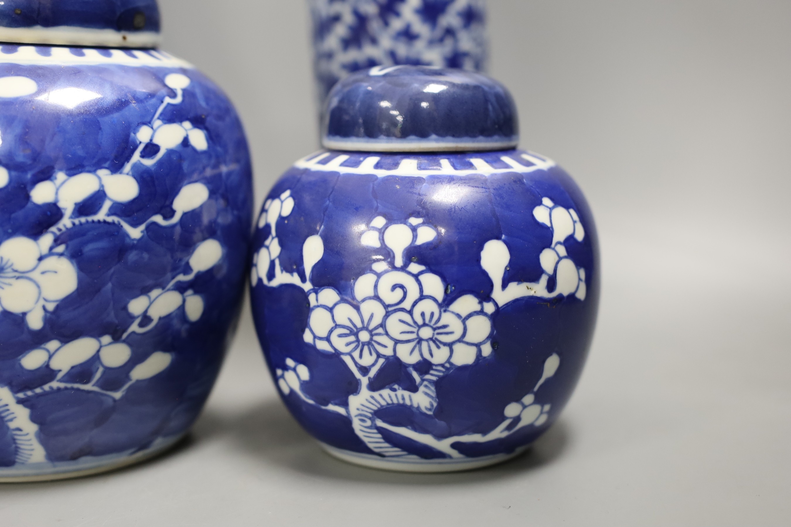 A 19th century Chinese blue and white ‘landscape’ vase, an early 20th century blue and white sleeve vase and three blue and white jars and covers. Tallest 25.5cm